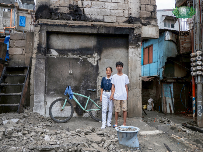 Tzu Chi volunteer Wilma Buenaventura (left) and her grandson, Tzu Chi scholar Daniel Buenaventura visit the empty space that used to be their home.