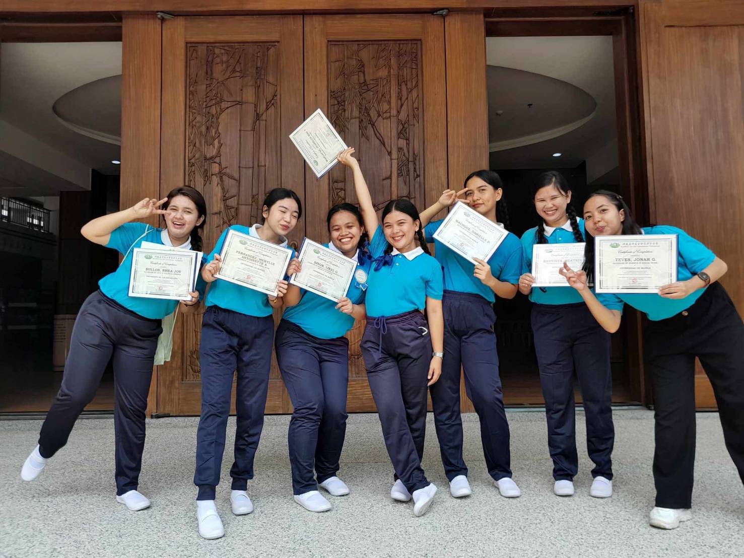 (Third from right) Holding up her certificate after symbolic graduation rites for Tzu Chi scholars