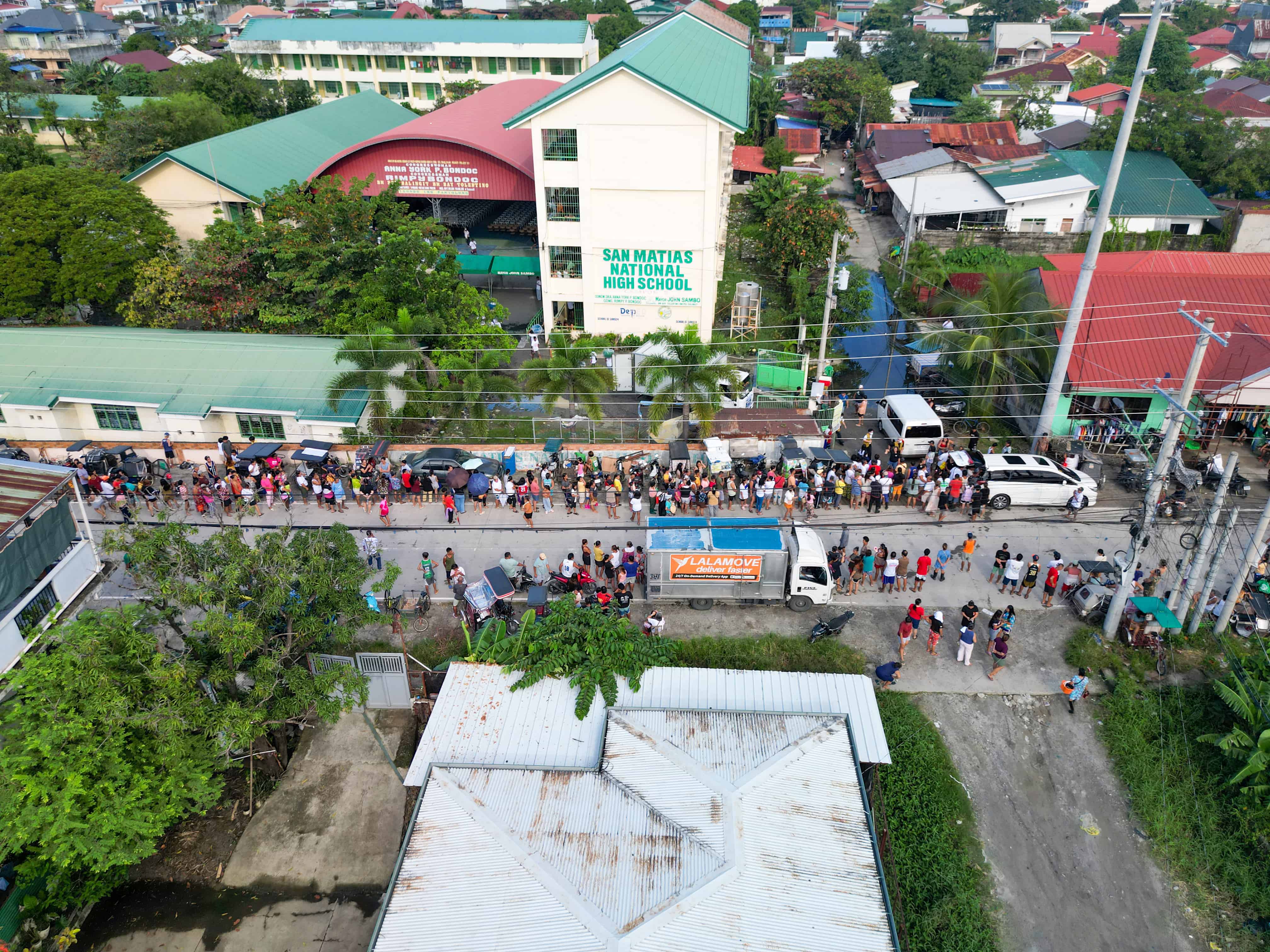 Beneficiaries line up early on September 19 at San Matias National High School, hoping to receive much-needed relief assistance.