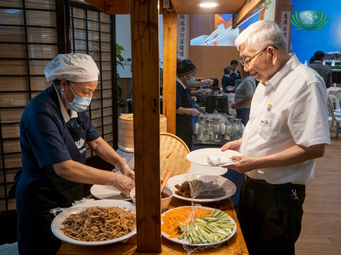 Tzu Chi volunteer Siu Siu (Lee-Ching Lu, left) led the kitchen team in preparing and serving a vegetarian dinner, warmly enjoyed by the medical practitioners.