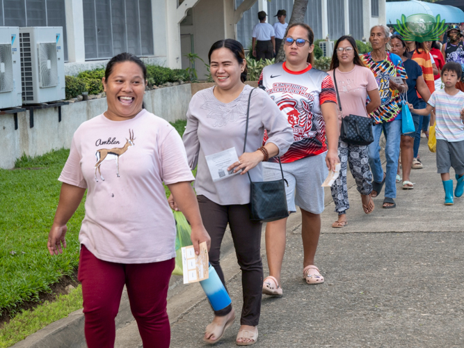 Beneficiairies are all smiles as they line up in an orderly manner to claim relief at the Sisters of Mary Girlstown in Talisay.