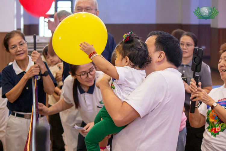 A young preschooler catches the balloon volleyball.