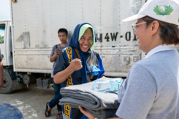Elizabeth Tunacao smiles as she receives her relief goods.