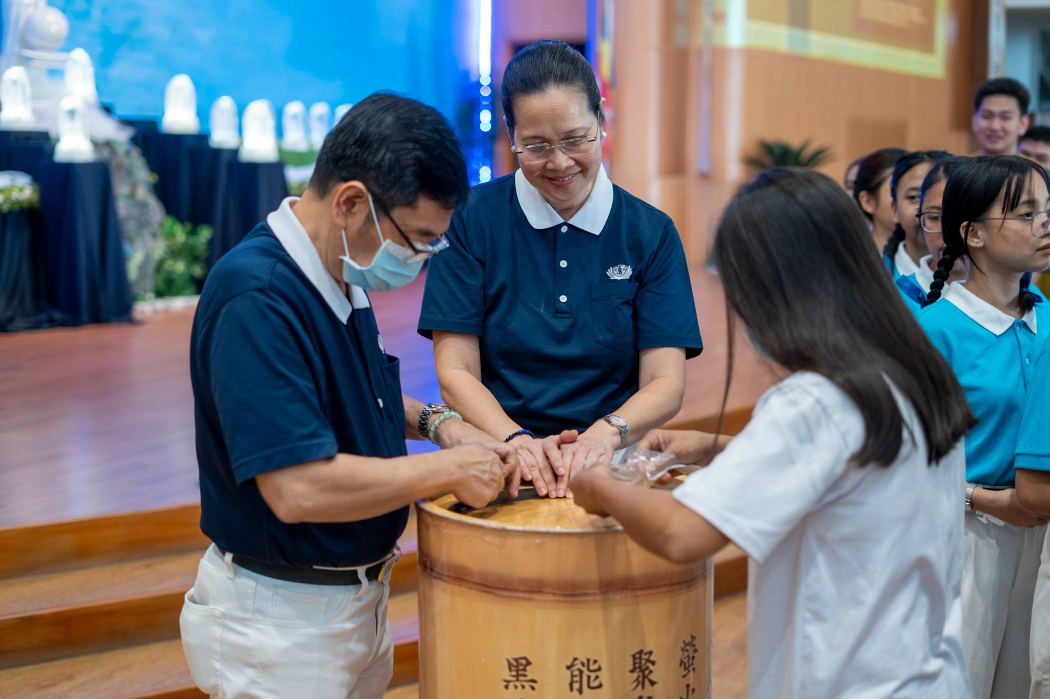 With bright smiles, dedicated Tzu Chi volunteers facilitate the coin bank donations, supporting the scholars' education fund.