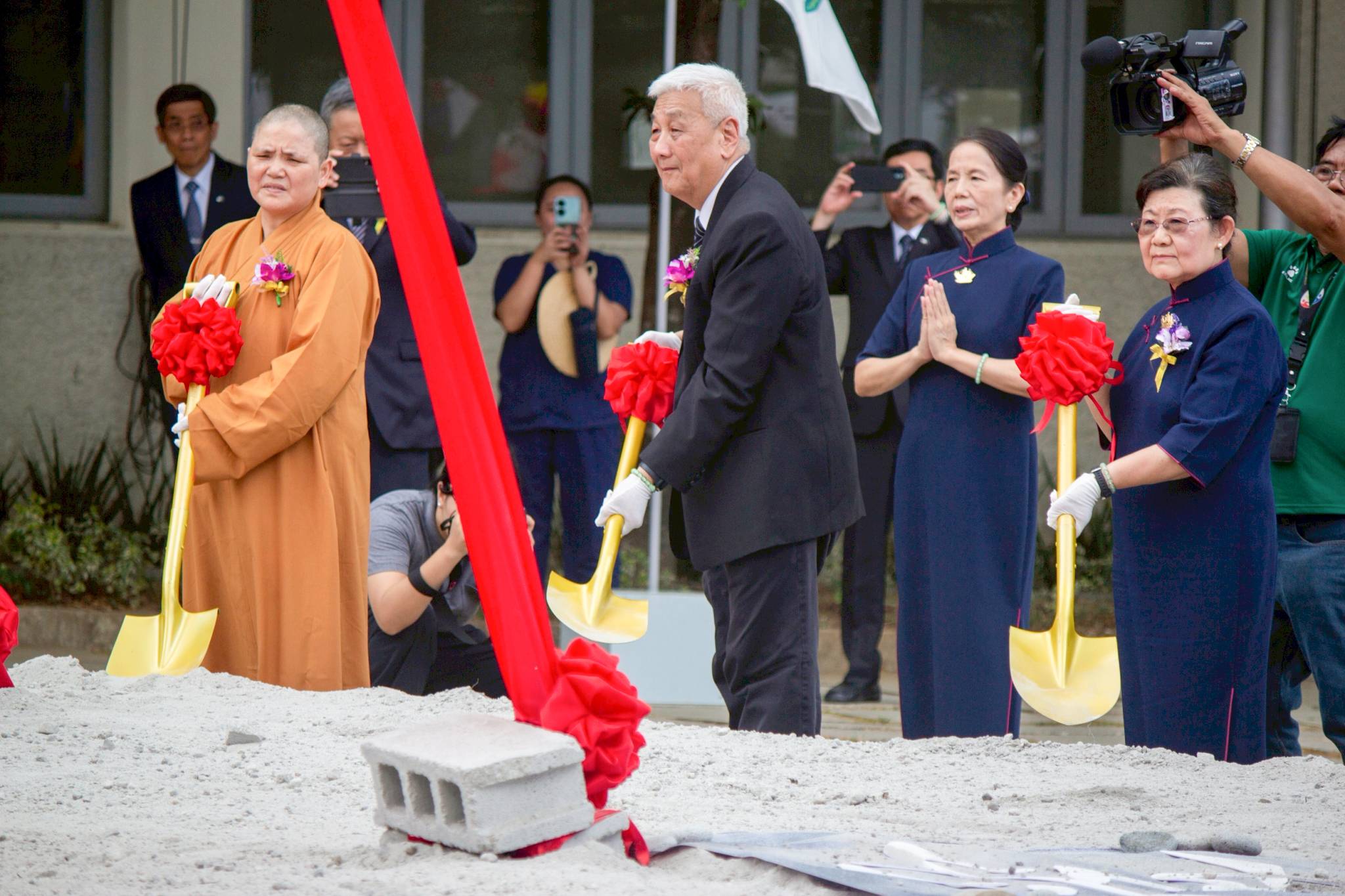 Tzu Chi Philippines CEO Henry Yuñez leads the symbolic shoveling of gravel at the groundbreaking ceremony.