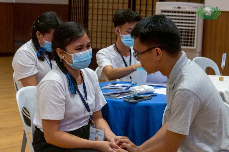 Albert Briongos (right) comforts a scholar after his talk on filial piety brings her and other scholars to tears.
