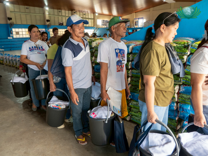 Residents lined up with hope, using buckets to receive the remaining items from the donation.