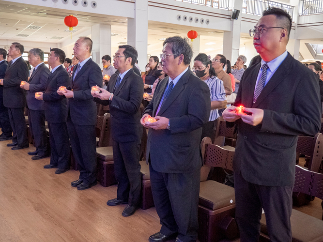 Participants raise a lighted candle as they pray for better things ahead.