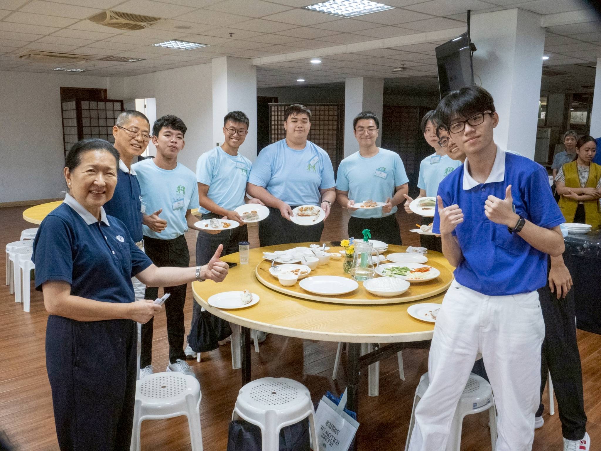 Tzu Chi volunteer Sally Yuñez (first from left) gives her thumbs up as judge of a cooking session where campers assemble fresh spring roll with vegetarian ingredients. 