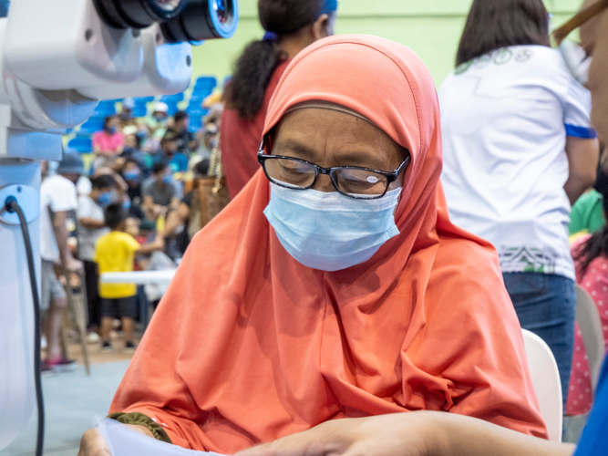 A patient tries the reading glasses given to her after the consultation with Dr. Magan. 【Photo by Matt Serrano】