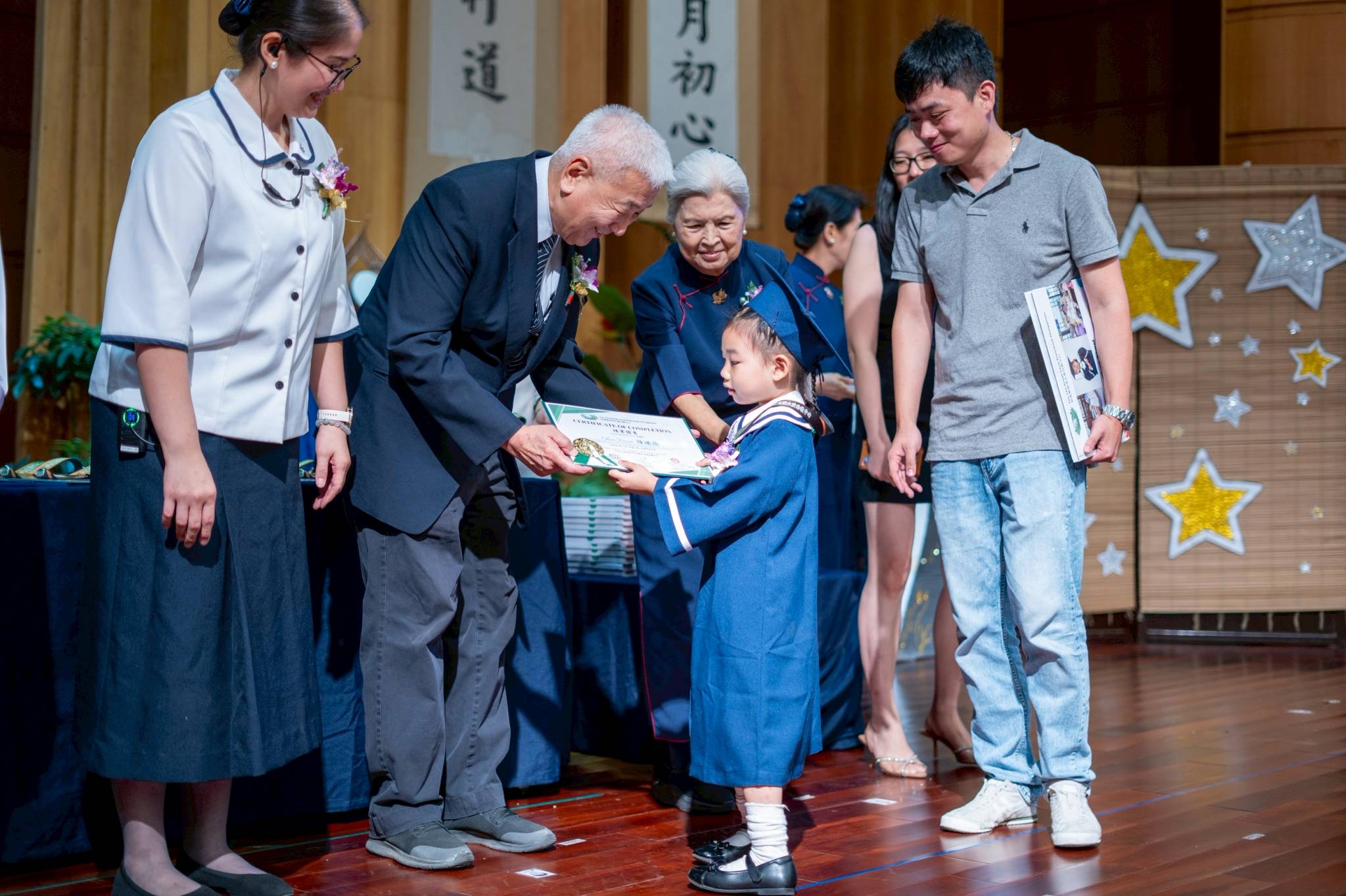 Accompanied by family members, pre-kindergarten and nursery students receive their certificates from Tzu Chi Philippines CEO Henry Yuñez, school directress Jane Sy (left), and Tzu Chi’s first CEO, Linda Chua (center).