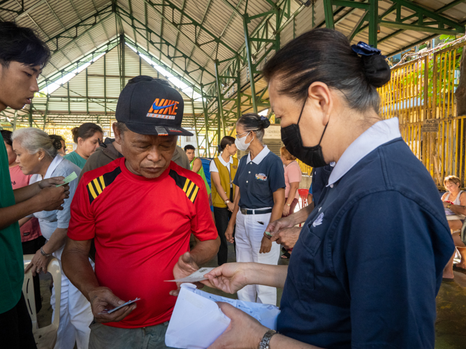 Residents claim their relief goods from Tzu Chi volunteers. 【Photo by Matt Serrano】