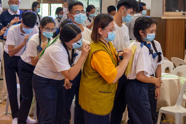 Group activities, like this one that requires participants to write a positive message to the person standing before them on a paper stuck to their back, encourages scholars to express themselves and make new friends.  【Photo by Matt Serrano】