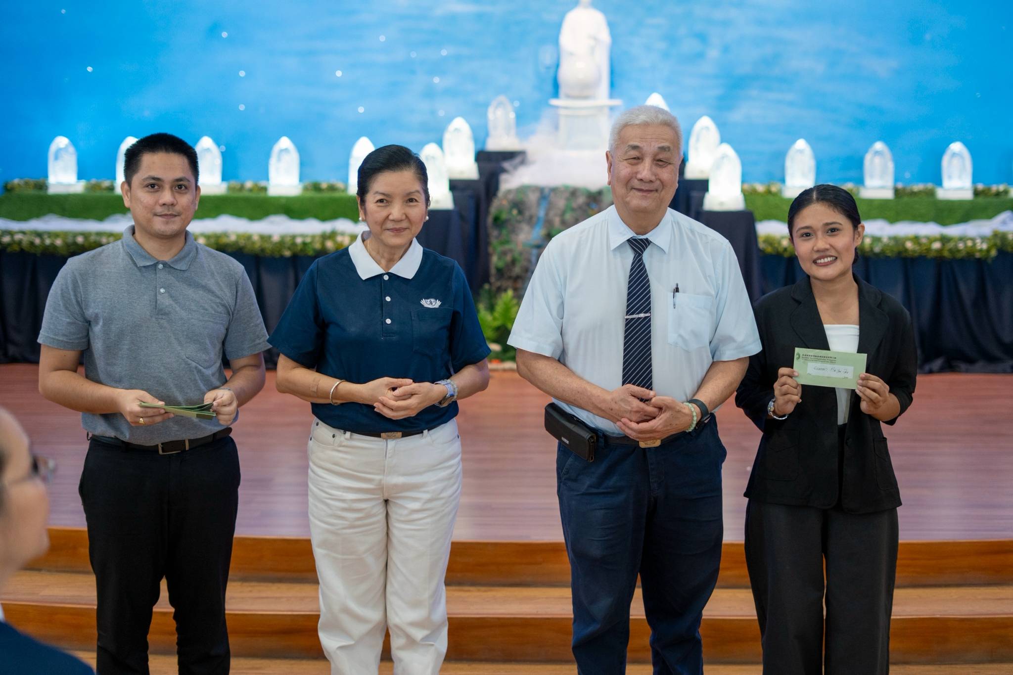 (From left) Tzu Chi Charity Department Head Mine Heart Tantoy, Head Volunteer for Tzu Chi’s Educational and Medical Assistance Programs Rosa So, and Tzu Chi Philippines CEO Henry Yuñez award Tzu Chi alumni scholars with  cash incentives for  graduating with Latin honors.