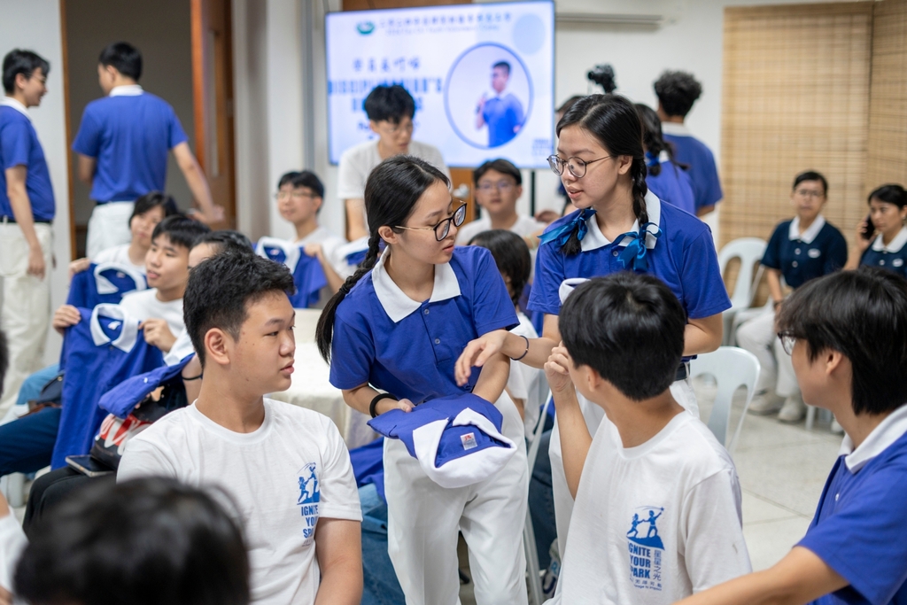 Tzu Chi Youth camp committee members help newly inducted youth with their uniforms.