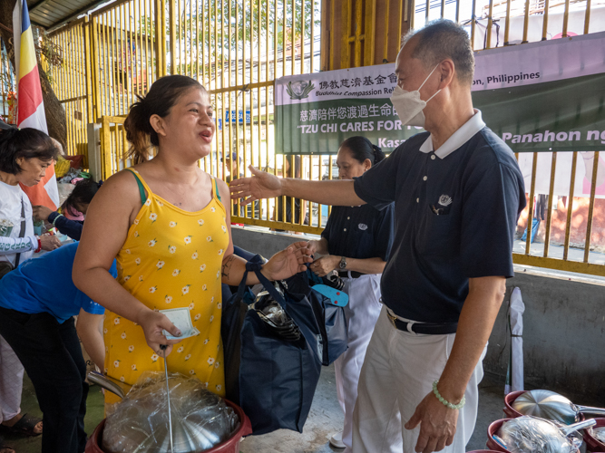 Residents claim their relief goods from Tzu Chi volunteers. 【Photo by Matt Serrano】