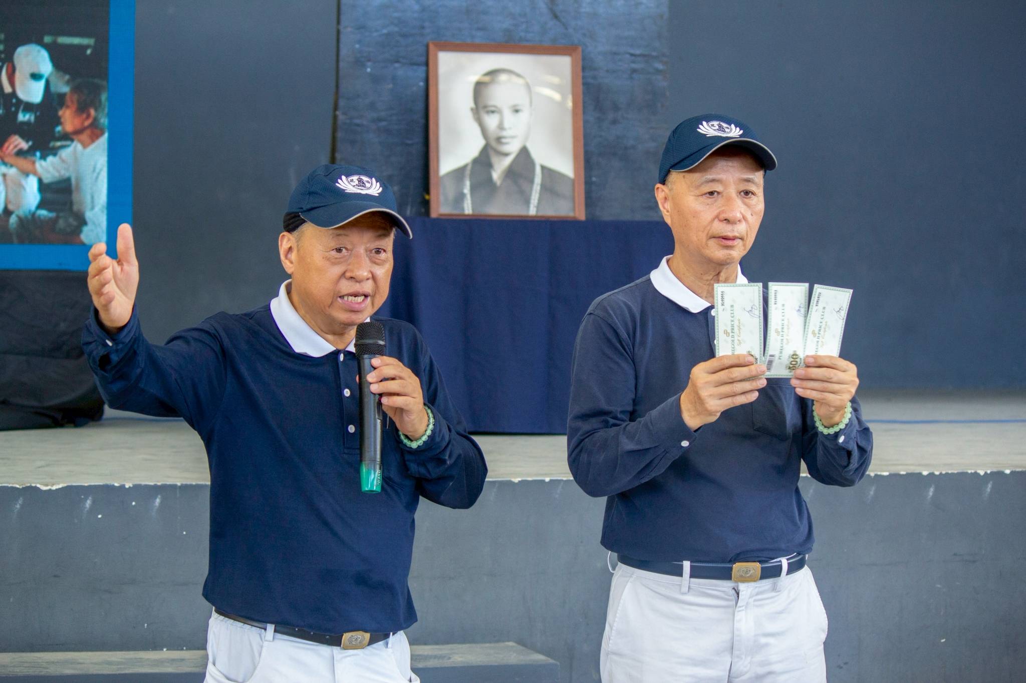 Tzu Chi volunteers Johnny Kwok (left) and Luis Diamante explain how beneficiaries can use their grocery gift check. 