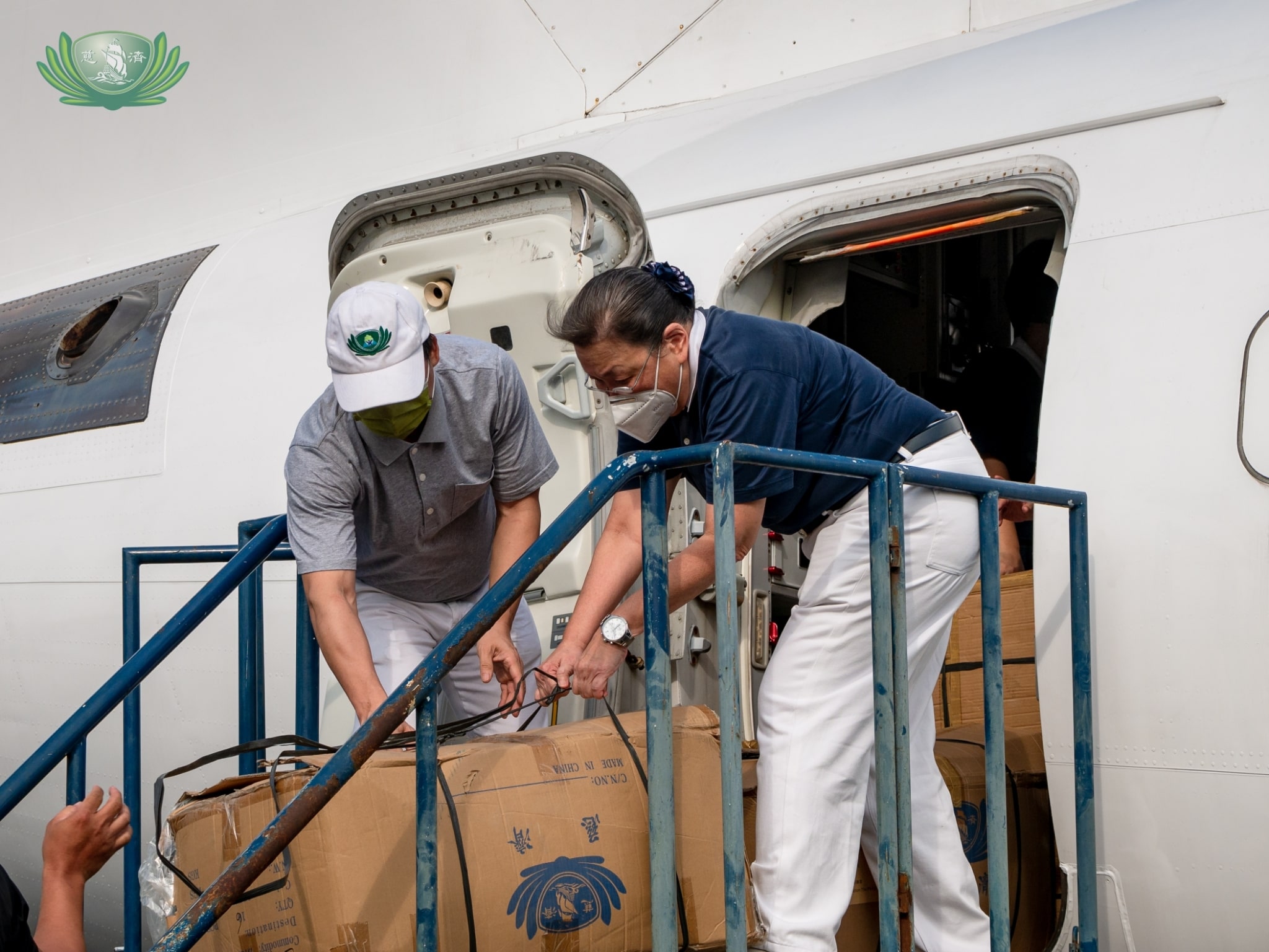 Volunteers work together to load boxes of fleece blankets into the private plane. 【Photo by Daniel Lazar】
