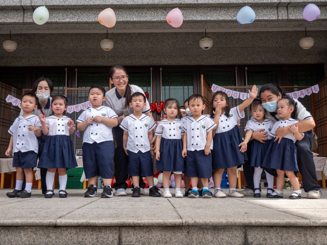 Nursery students, together with teacher Marian “Yani” Carpo (second row, leftmost), Directress Jane Sy (second row, center), and teacher Mary Ann Rodriguez (second row, rightmost) pose for a photo after their performance.