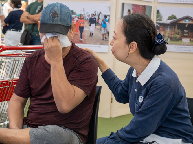 Tzu Chi volunteer Peggy Sy-Jiang (right) comforts Erwin Rivas, who tears up recalling how Super Typhoon Yolanda took the lives of his 44-year-old brother-in-law and 12-year-old nephew. 【Photo by Matt Serrano】