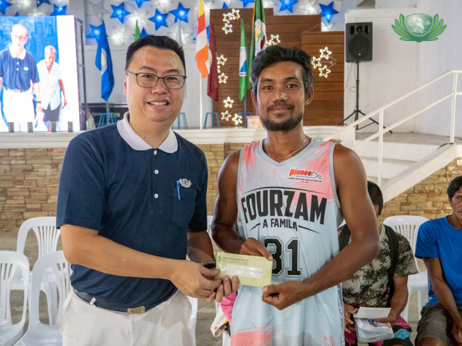 Tzu Chi Philippines Deputy CEO Wilson Hung (left) hands cash assistance to beneficiary Alfred Danao.
