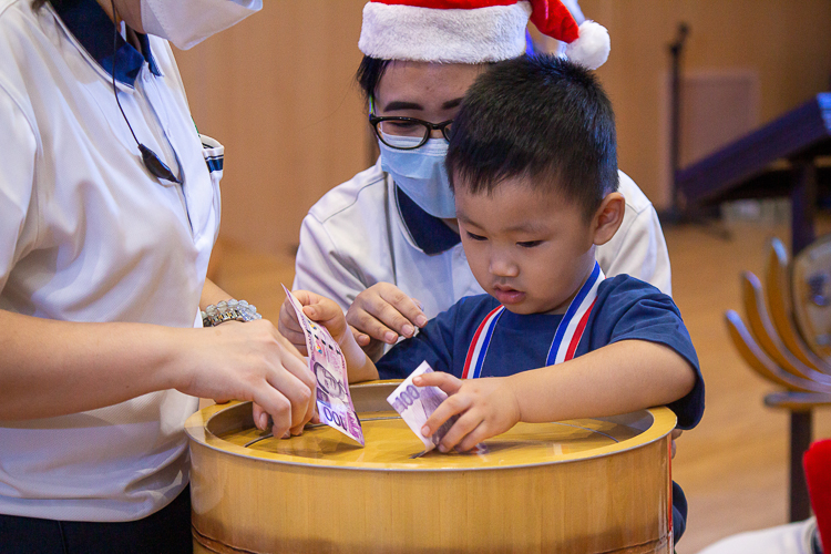 The preschool students share love and blessings for Tzu Chi’s beneficiaries through coin bank donations.【Photo by Marella Saldonido】