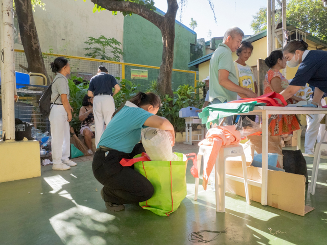 A Tzu Chi scholar packs a customer’s purchased items. 【Photo by Dorothy Castro】