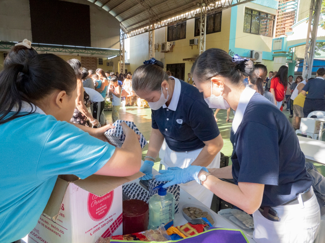 Tzu Chi volunteers and a Tzu Chi scholar work together to pack the fragile items bought by a customer. 【Photo by Dorothy Castro】
