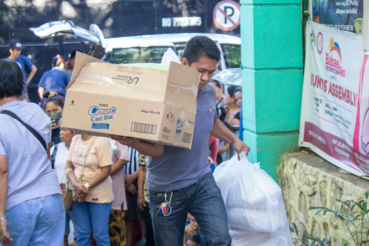 A Tzu Chi staff carries items to be sold at the bazaar. 【Photo by Marella Saldonido】