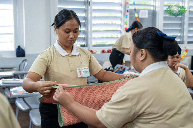 With a fellow caregiving scholar, Merequiel Gallito learns how to properly fold an underpad. 