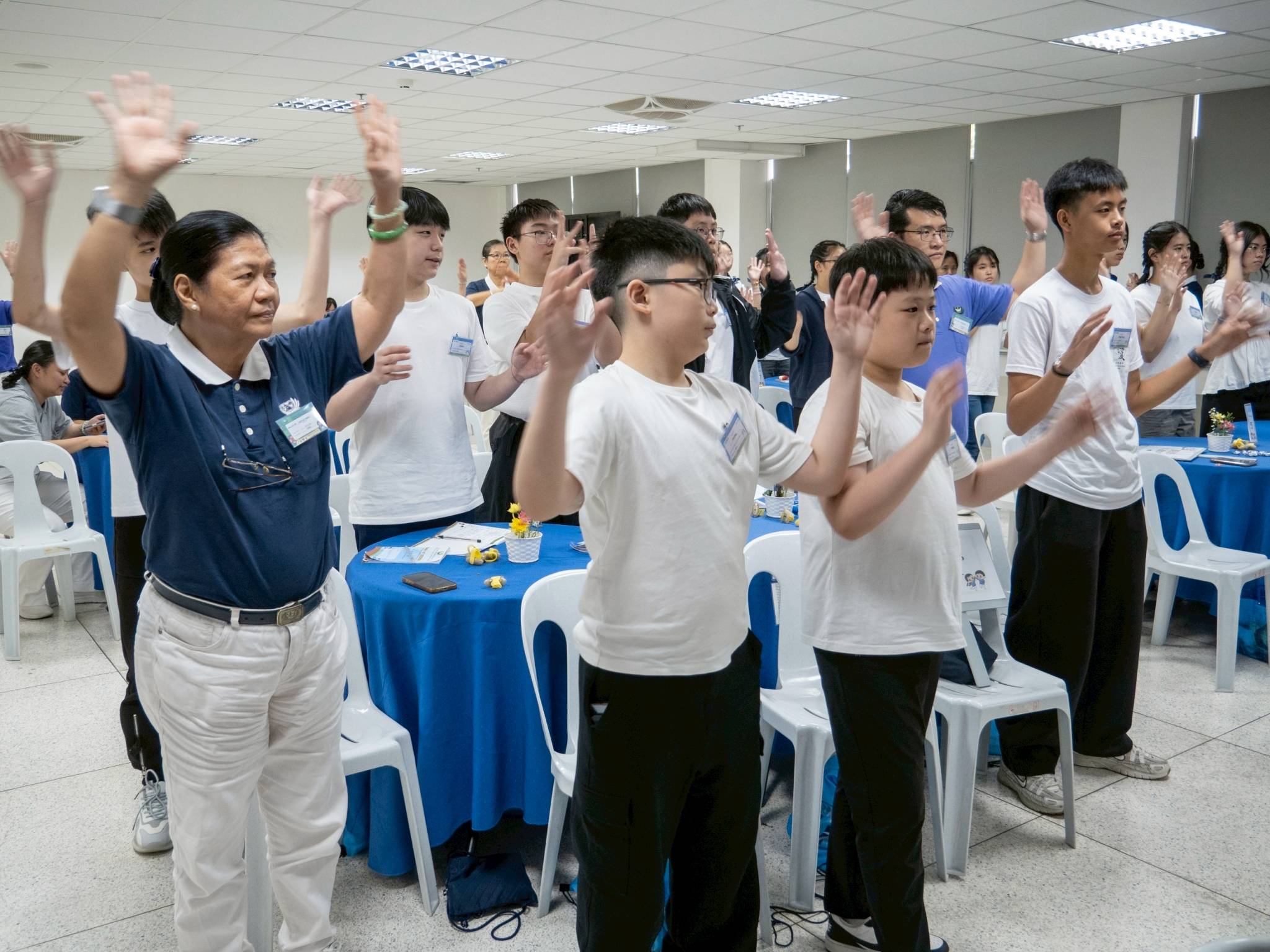 Using sign language to interpret songs is part of Tzu Chi culture. Here, participants learn the moves to the camp song “The Light.” 