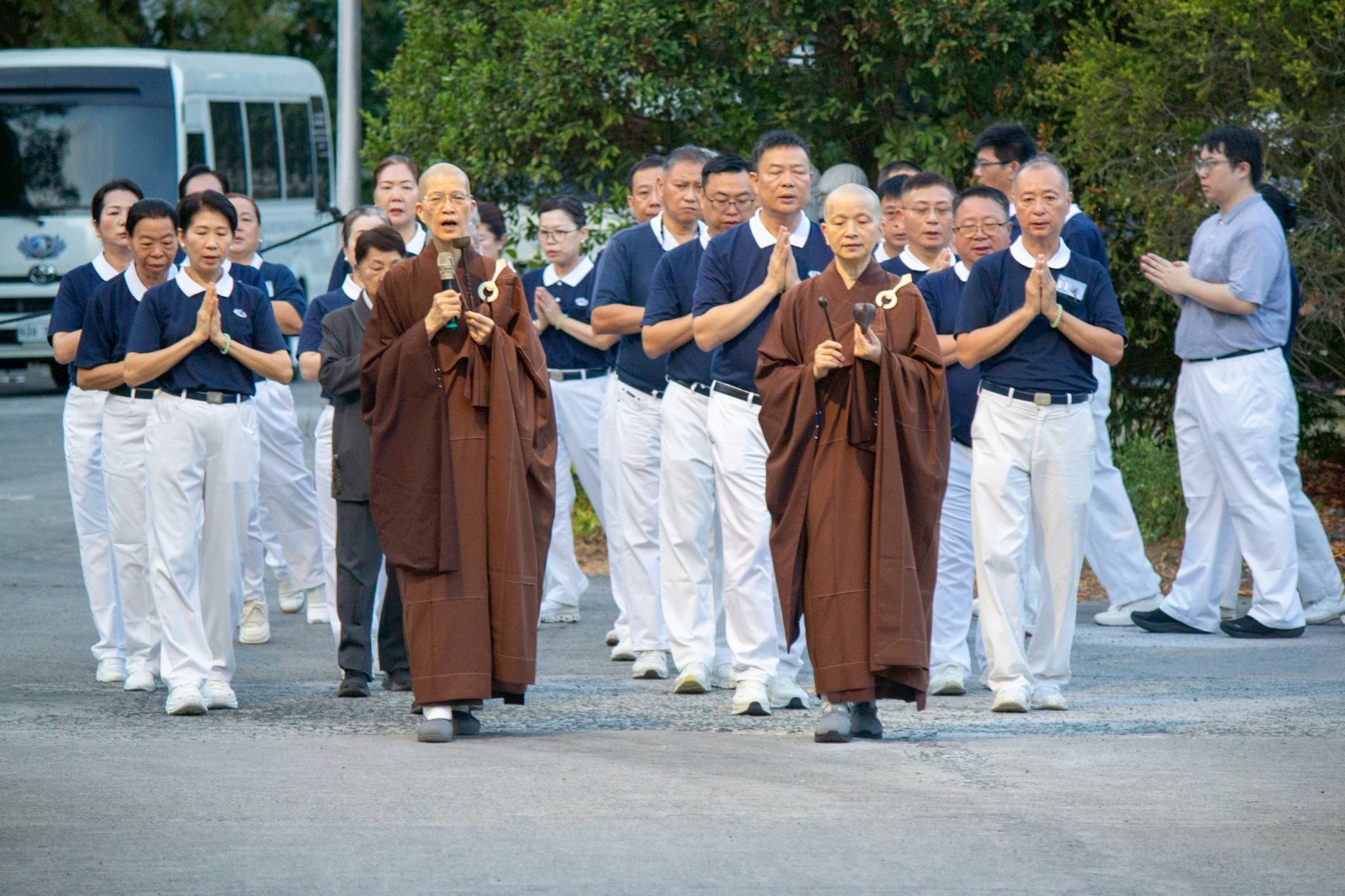 Hours before the groundbreaking rites, Dharma Masters De Pei and De Yue from Hualien, Taiwan, lead a walking prayer meditation for Tzu Chi volunteers at the BTCC grounds. 