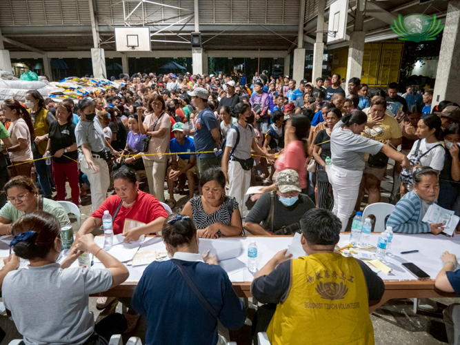Staff and volunteers manage the busy registration table on Day 1, releasing stubs to organize relief distribution efficiently.