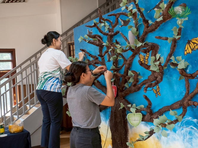 Tzu Chi volunteers prepare the Million Leaves of Love board, where donors hang symbolic red and green leaves to fund the construction of the Tzu Chi General Hospital.