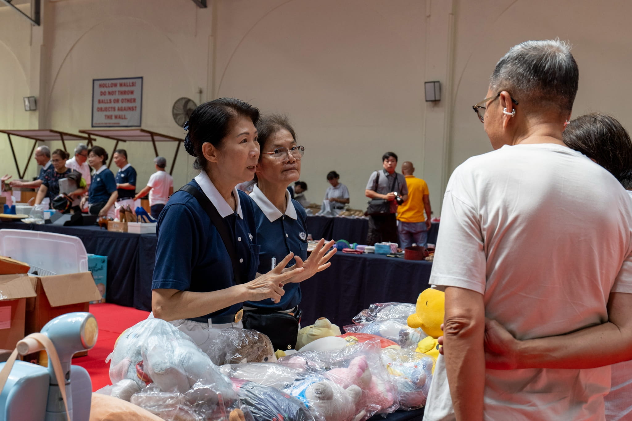 Tzu Chi volunteers Woon Ng (left) and Elvira Chua entertain shoppers’ queries about the bazaar’s cause.