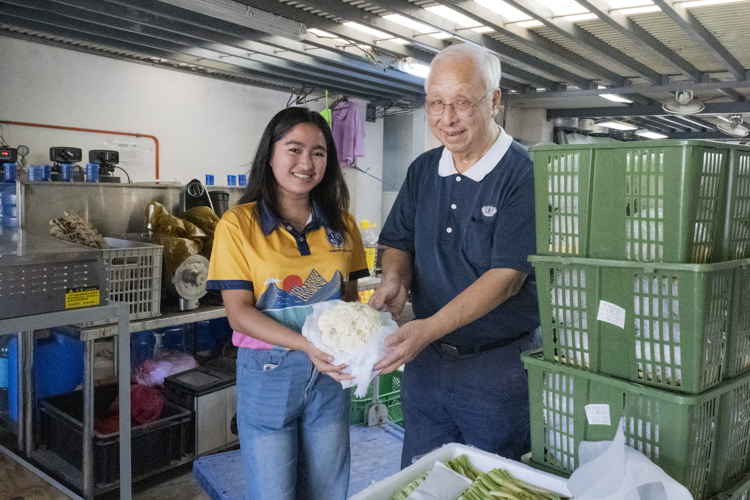 Social worker Rosalyn Endriga and Tzu Chi volunteer James Cheng pose for a photo with the donated vegetables received for their charity. 
