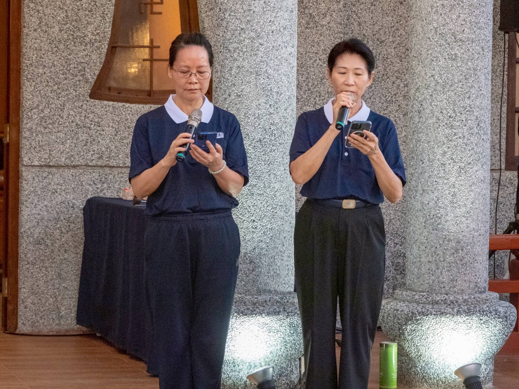 Tzu Chi volunteers Lin Shanya (left) and Woon Ng graciously welcome fellow volunteers, scholars, families, and honored guests to the annual celebration.