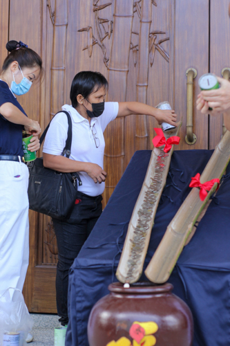 Raquel Tolitol empties the contents of the seven Tzu Chi coin banks she collected for Charity Day. “I wanted to return the help that Tzu Chi has given us,” she says.【Photo by Jeaneal Dando】