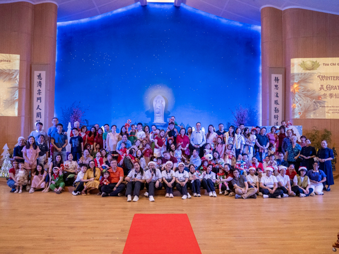 Students, parents, teaching and non-teaching staff, and Tzu Chi volunteers pose for a group photo after the thanksgiving concert.