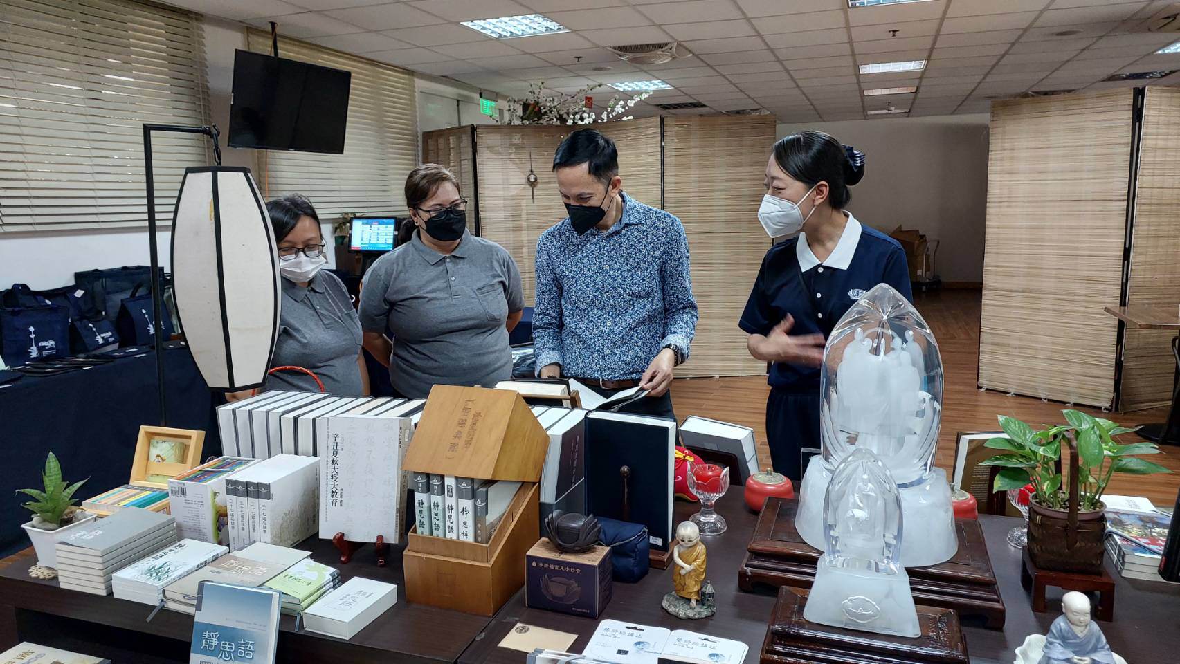 Flanked by Tzu Chi volunteers (from left) Tina Pasion, Dolly Alegado Cruz and Peggy Sy (extreme right), Mayor Shierwin Taay of Dingalan, Aurora, checks out items in the Tzu Chi bookstore.【Photo by Jerom Bacarra】