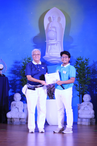 Graduating magna cum laude, scholar Joshua Daarol (right) accepts a certificate from Tzu Chi Philippines CEO Henry Yuňez.【Photo by Matt Serrano】
