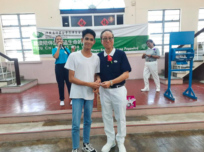 Tzu Chi Bicol volunteer Antonio “Tony” Tan hands out special prizes to raffle and contest winners at Tzu Chi Bicol’s Christmas party. 【Photo by Tzu Chi Bicol】