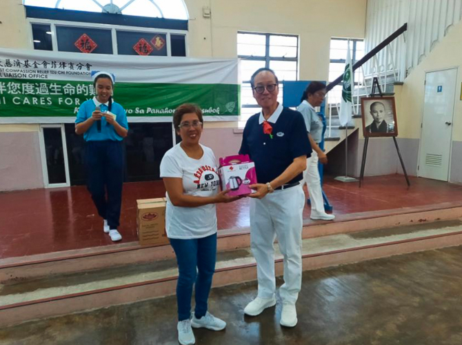 Tzu Chi Bicol volunteer Antonio “Tony” Tan hands out special prizes to raffle and contest winners at Tzu Chi Bicol’s Christmas party. 【Photo by Tzu Chi Bicol】