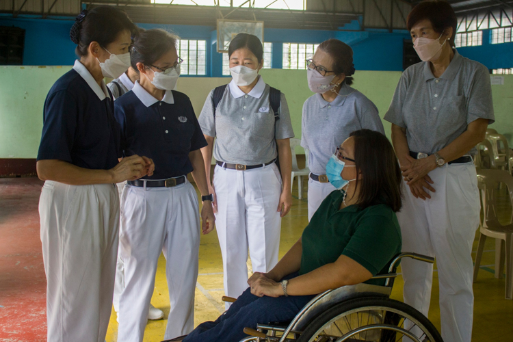 Tzu Chi volunteers chat with Tahanang Walang Hagdanan HR Manager Maria Belen Pacete. 【Photo by Matt Serrano】