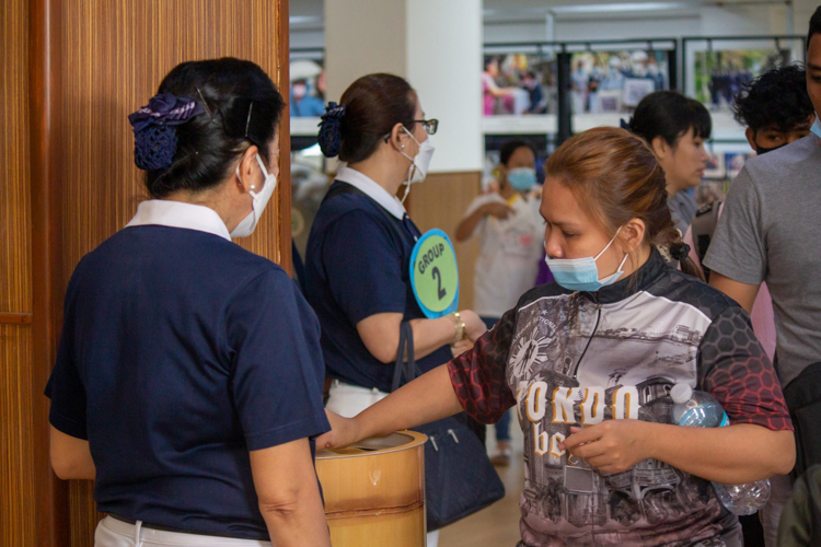 Guests drop donated coins in Tzu Chi’s large coin bank. 【Photo by Marella Saldonido】