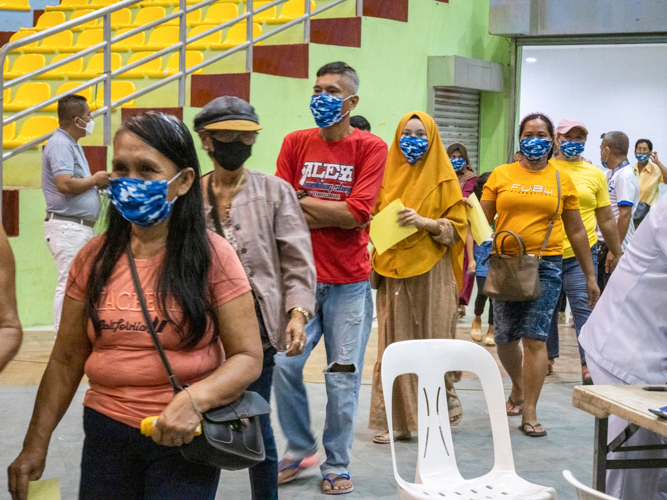 Patients enter the gymnasium in an orderly manner. 【Photo by Matt Serrano】