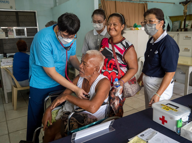 At the general medicine area, Dr. Tommy Yau checks stroke survivor Leo Gabat-bat. The TIMA doctor prescribed medication for his hypertension and diabetes. “Thank you to everyone who helped me—from those who carried me in my wheelchair to the consultation area to those who gave me free medicines. I’m very grateful to all,” says Gabat-bat. 