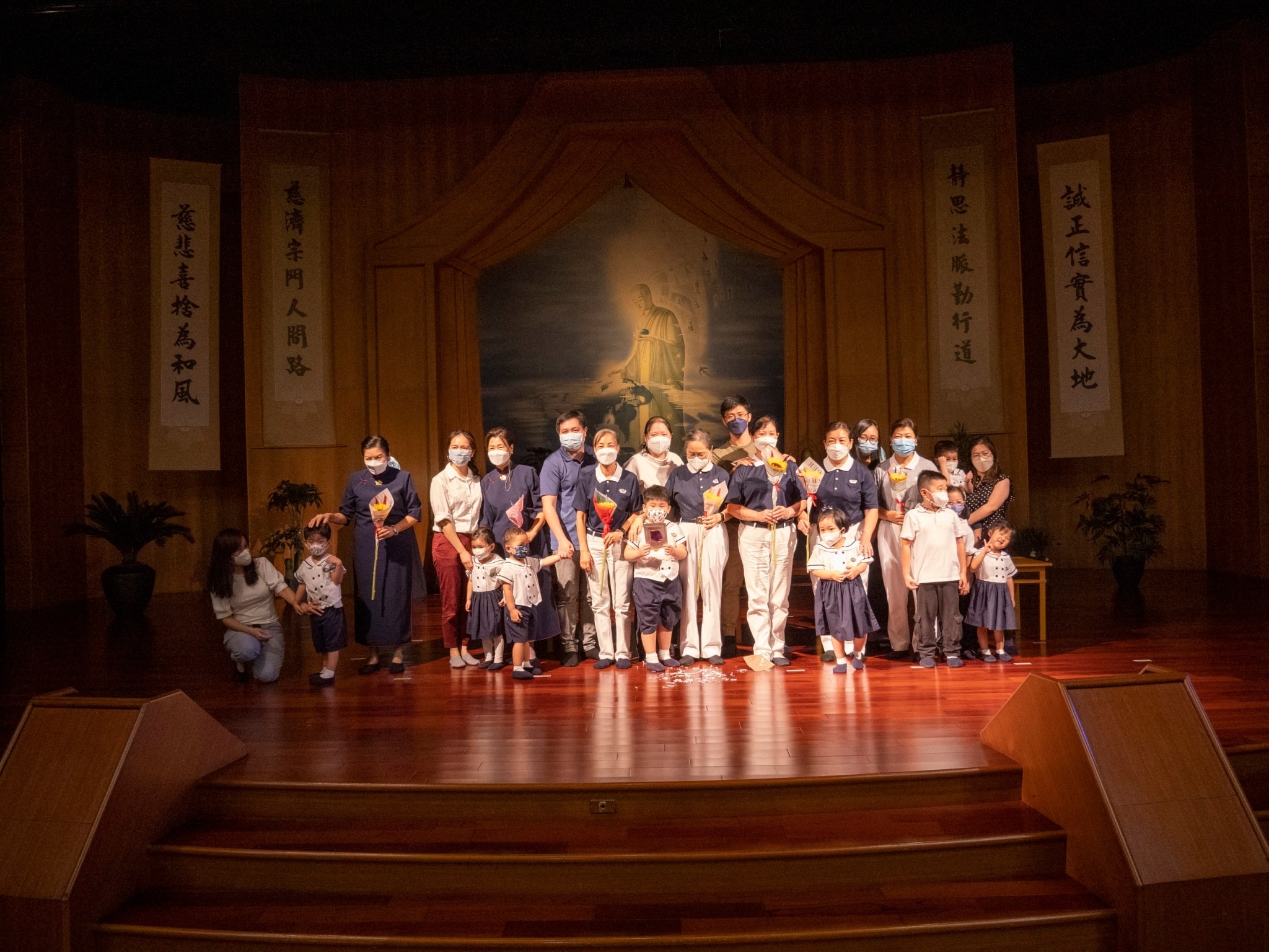 Families of Tzu Chi volunteers present flowers to their mothers. 【Photo by Matt Serrano】