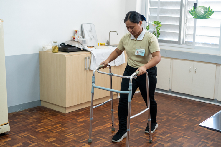 Tzu Chi’s caregiving course allows scholars like Merequiel Gallito to familiarize themselves with assistive devices like a walker. 