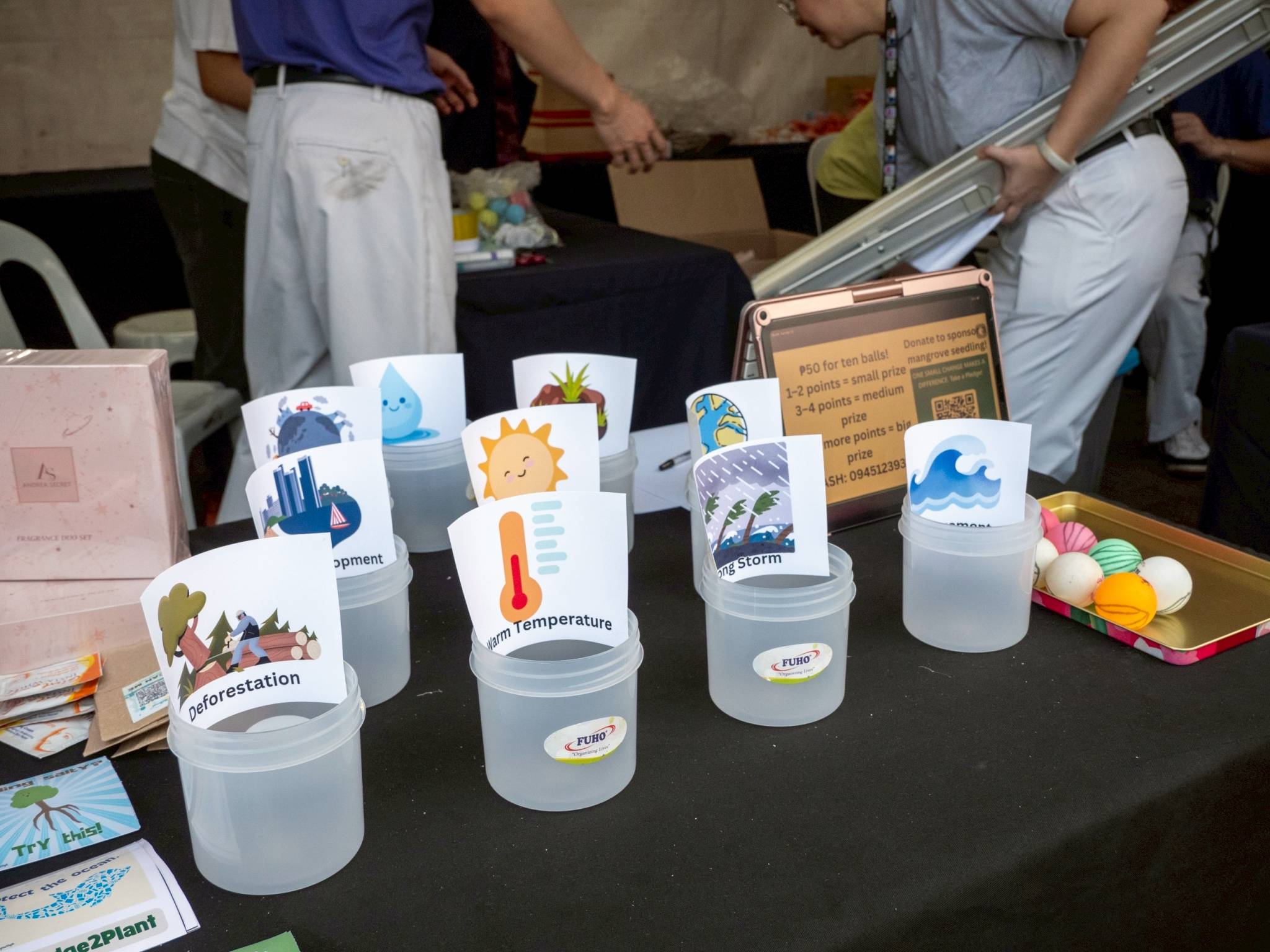 The game of shooting ping-pong balls into cups containing drawings of “essentials” and “threats” to planting a mangrove seedling is a nod to Tzu Chi Youth’s upcoming mangrove-planting program. 